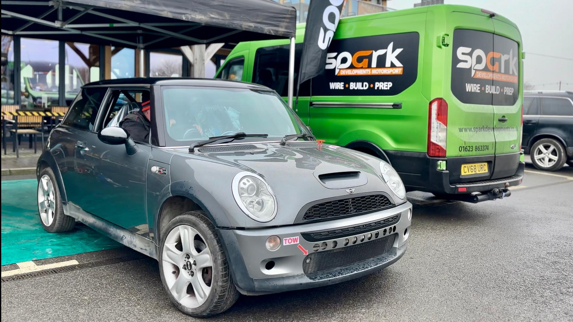 Mini rally car near Spark van